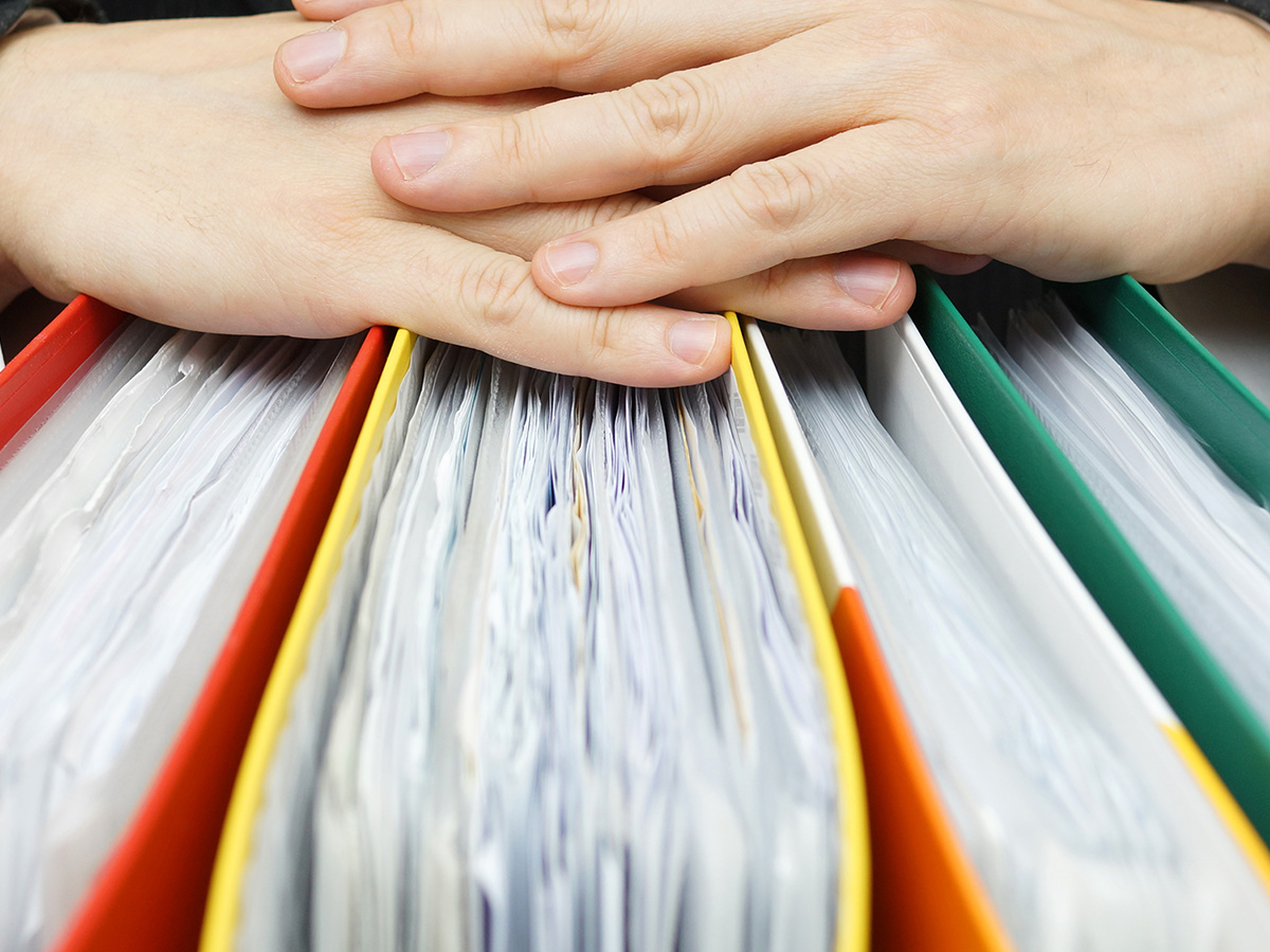 Man's hands resting on documents